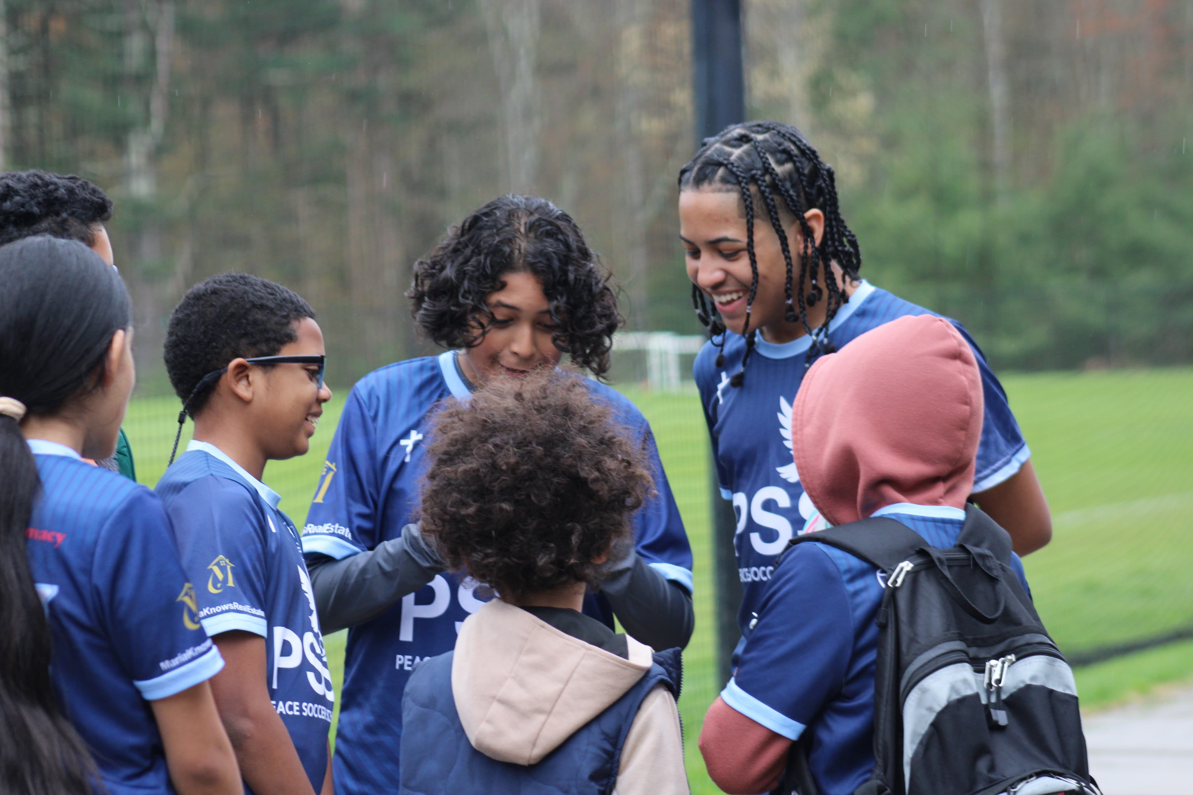 Players laughing together at Peace Soccer School
