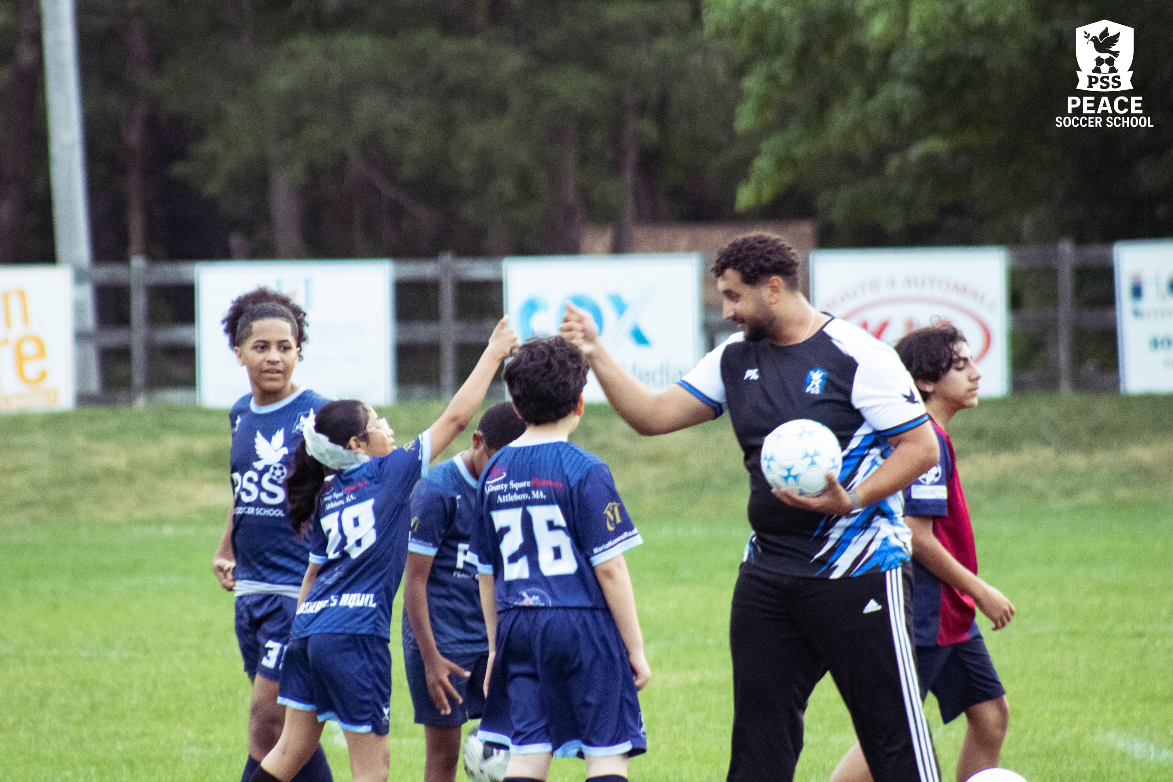 Coach high-fiving player at Peace Soccer School