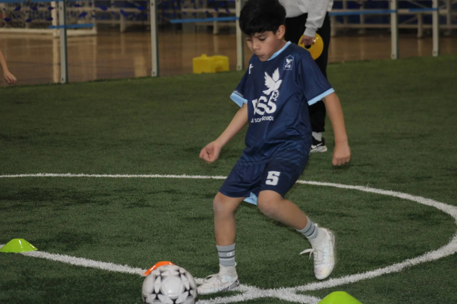 Youth soccer player in PSS jersey doing agility drills
